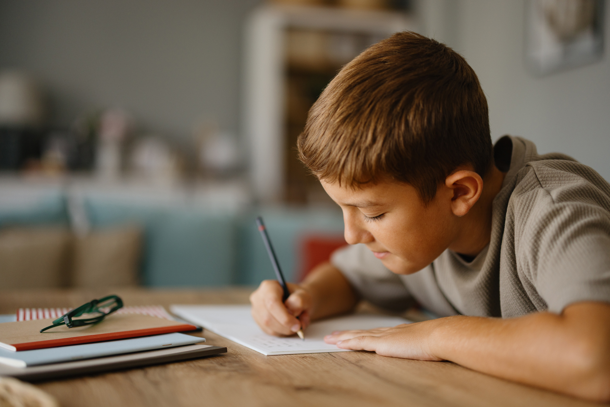 Elementary age boy concentrating on doing homework at home